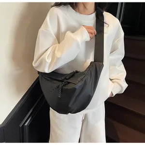 Detail of black crescent canvas bag featuring double braided rope zipper and nylon strap