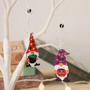 Halloween wooden gnome ornaments with pumpkin and cauldron hanging on a white decorative tree