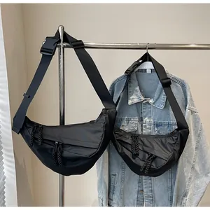Detail of black pleated crescent crossbody bags with adjustable straps and rope zippers