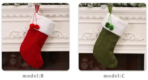 Detail of red and green knitted Christmas stockings with white faux fur trim and pom-poms