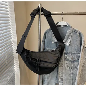 Close-up of black canvas crescent bag with textured woven zipper pulls on metal slider