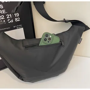 Detail showing internal space of black crescent bag with a smartphone inside
