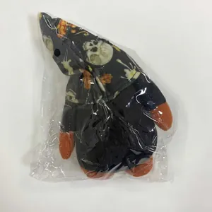 Detail view of Halloween gnome plush toy with skull and pumpkin patterns in clear packaging
