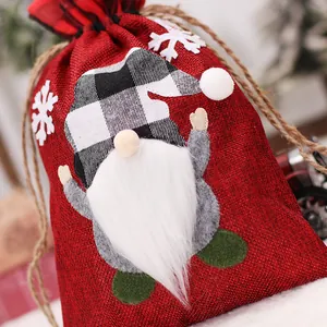 Kerst cadeauzakje van jute met kabouter-applicatie en witte sneeuwvlok decoraties