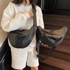 Black nylon crescent crossbody bag with adjustable wide strap shown on a model