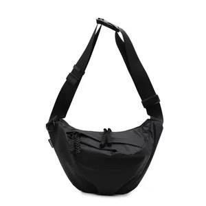 Black nylon crescent crossbody bag with adjustable strap and fashion label on white background