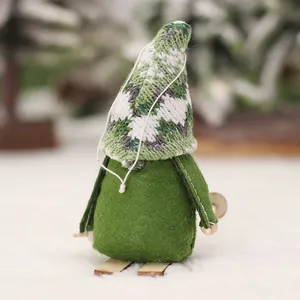 Green knit gnome ornament with tree pattern hat on wooden sled for Christmas tree decor