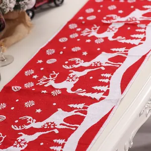 Kerst gebreide tafelloper met rendier- en sneeuwvlokpatronen op een rode feestelijke stof