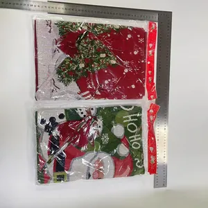 Detalle de camino de mesa navideño con motivos tejidos de Papá Noel y bordes de borlas