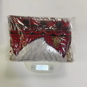 Camino de mesa navideño de jacquard doblado mostrando el peso en la báscula