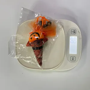 Misura del peso di una bambola sospesa a zucca di Halloween con rete arancione e ragno