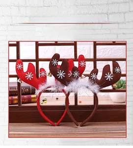 Detailed view of Christmas reindeer headbands with white feathers and bells on a wooden base