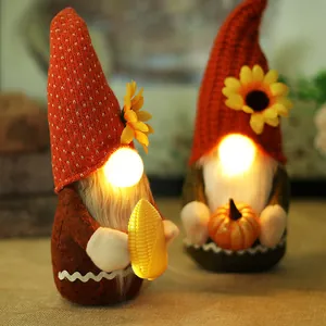 Two lighted Thanksgiving gnomes with LED noses and sunflower hats for autumn home decor