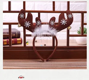 Close-up of reindeer antler headband with white snowflakes, gold bells and soft feathers