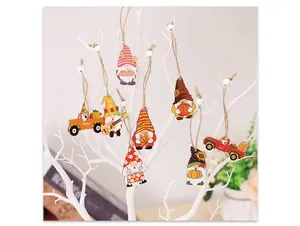 Detail of wooden gnome and farm truck ornaments hanging on a white decorative tree