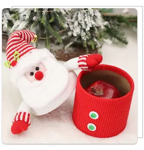 Detail of knitted Santa Claus candy jar with red fabric and golden bell decoration