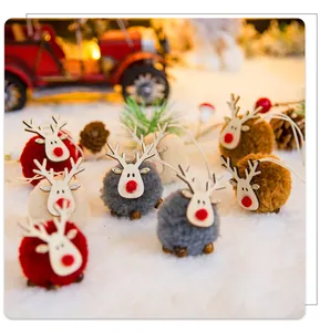 Detalle de renos de fieltro sobre nieve con piñas y adornos festivos de Navidad
