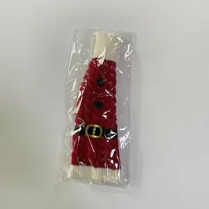 Macro shot of knitted Christmas elf wine bottle cover with festive red and white patterns