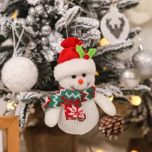 Adorable bonhomme de neige de Noël tricoté suspendu à un sapin enneigé festif