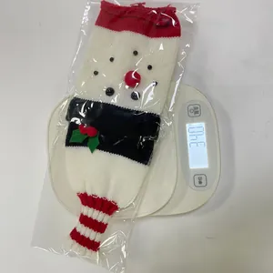 Detail of a Christmas snowman knitted bottle cover showing red white texture and weight