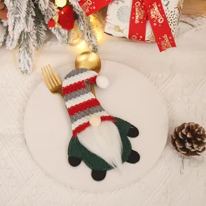 Christmas gnome cutlery holder with red striped hat on a festive dinner plate setup