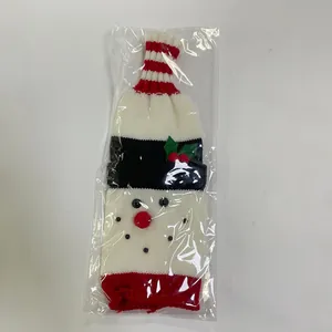 Detailed knit snowman wine bottle cover with red festive stripes and winter berry accent
