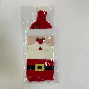 Macro view of Santa Claus knitted wine bottle cover with red hat and black belt