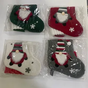 Détail de quatre chaussettes de Noël en tissu avec broderie de gnome et motifs flocons