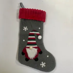 Détail de chaussette de Noël en peluche avec applique gnome et broderie flocon de neige