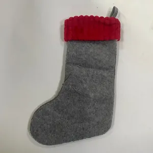 Détail d'une chaussette de Noël en feutre gris avec revers à rayures rouges