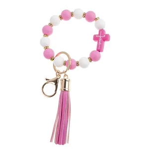 Detail of pink silicone bead keychain with Jesus cross pendant and purple tassel