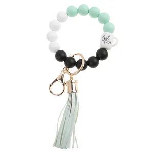 Detail of silicone bead keychain with leather tassel and Girl Boss coffee cup charm