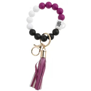Detail of silicone bead wristlet keychain with fringe tassel and wife mom boss charm