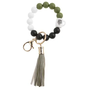 Detail of beaded keychain wristlet with green silicone beads and mini coffee cup charm