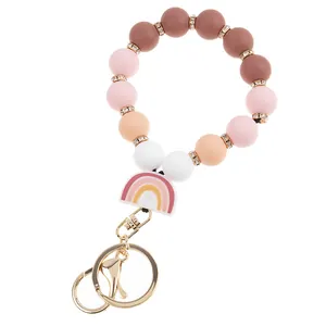 Detail view of silicone rainbow bead keychain bracelet with golden clasp and diamond spacers