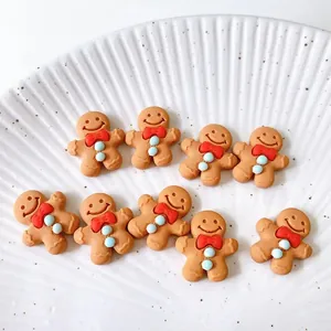 Set di 9 ciondoli omino di pan di zenzero in resina su un piatto di ceramica bianca decorativa