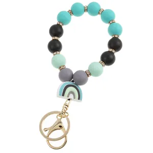 Detail of colorful silicone bead bracelet keychain with rainbow pendant and gold metal clasp
