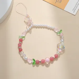 Detailed close-up of handmade beaded phone strap with tulip charms and a large heart pendant