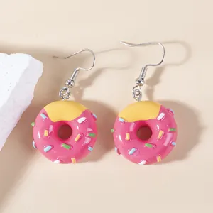 Sweet pink doughnut food-shaped earrings with colorful sprinkles on a soft beige background