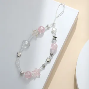 Handmade beaded phone strap with pink tulip beads and silver heart accents on white pedestal