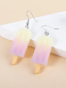 Detailed close-up of gradient ice cream earrings on a white geometric prop background