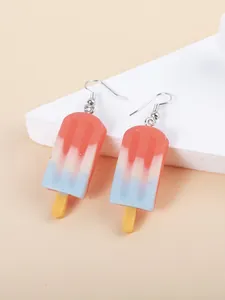 Close-up of tricolor popsicle earrings with red, white, and blue gradient on stone stand