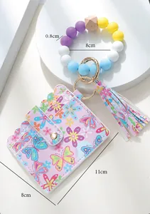 Macro shot of colorful silicone beaded keychain with printed floral PU leather wallet
