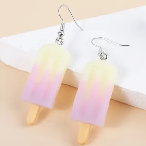 Creative ice cream popsicle earrings with pink gradient on white stone background