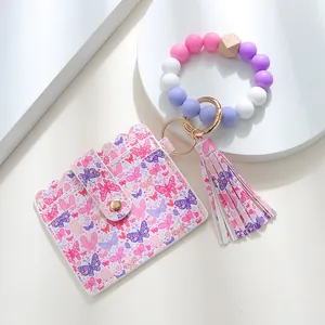 Close-up of pink butterfly print PU leather card holder with silicone bead bracelet