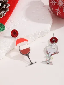 Detalle de los pendientes festivos de copa de vino de Navidad con gorro de Papá Noel y adornos