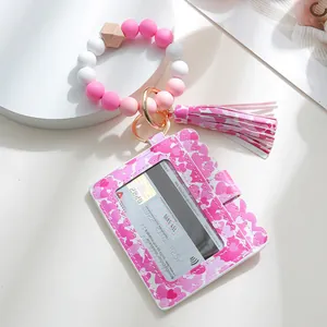 Detail of pink heart printed PU card holder with silicone bead bracelet and tassel keychain