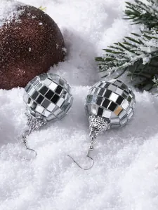 Detailed view of silver disco ball earrings with reflective mirror finish on Christmas tree