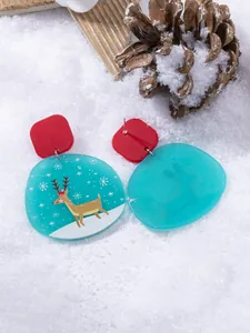 Detail of Christmas earrings featuring reindeer and snowflake prints on acrylic blue charms