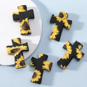 Cinq perles en silicone en forme de croix avec des motifs de tournesol jaune vif